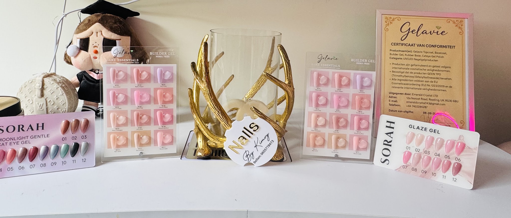 Vitrine met press-on nagels, een certificaat en het ronde Nails bordje