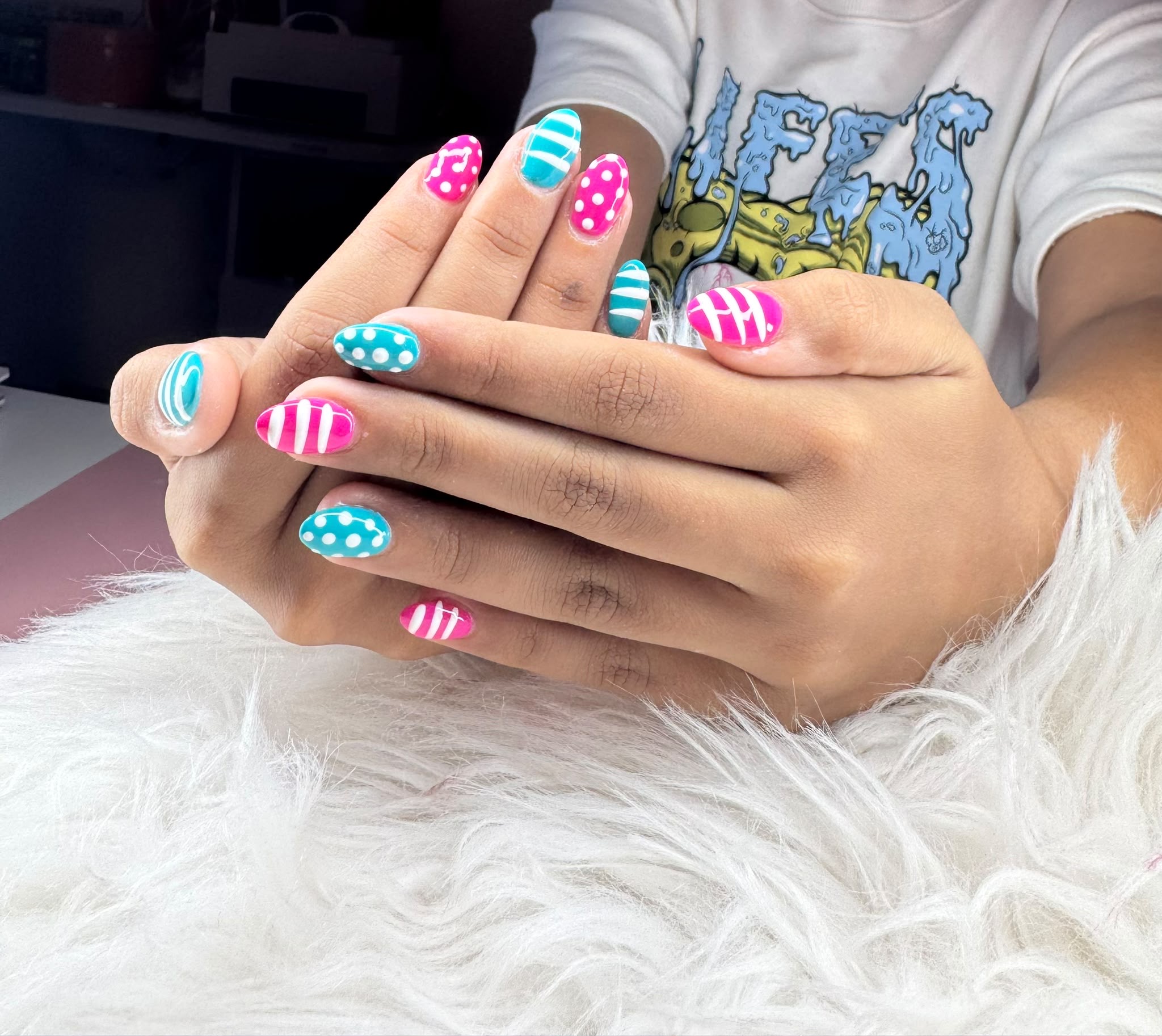 Vrolijke nagels met strepen en stippen in roze en blauw
