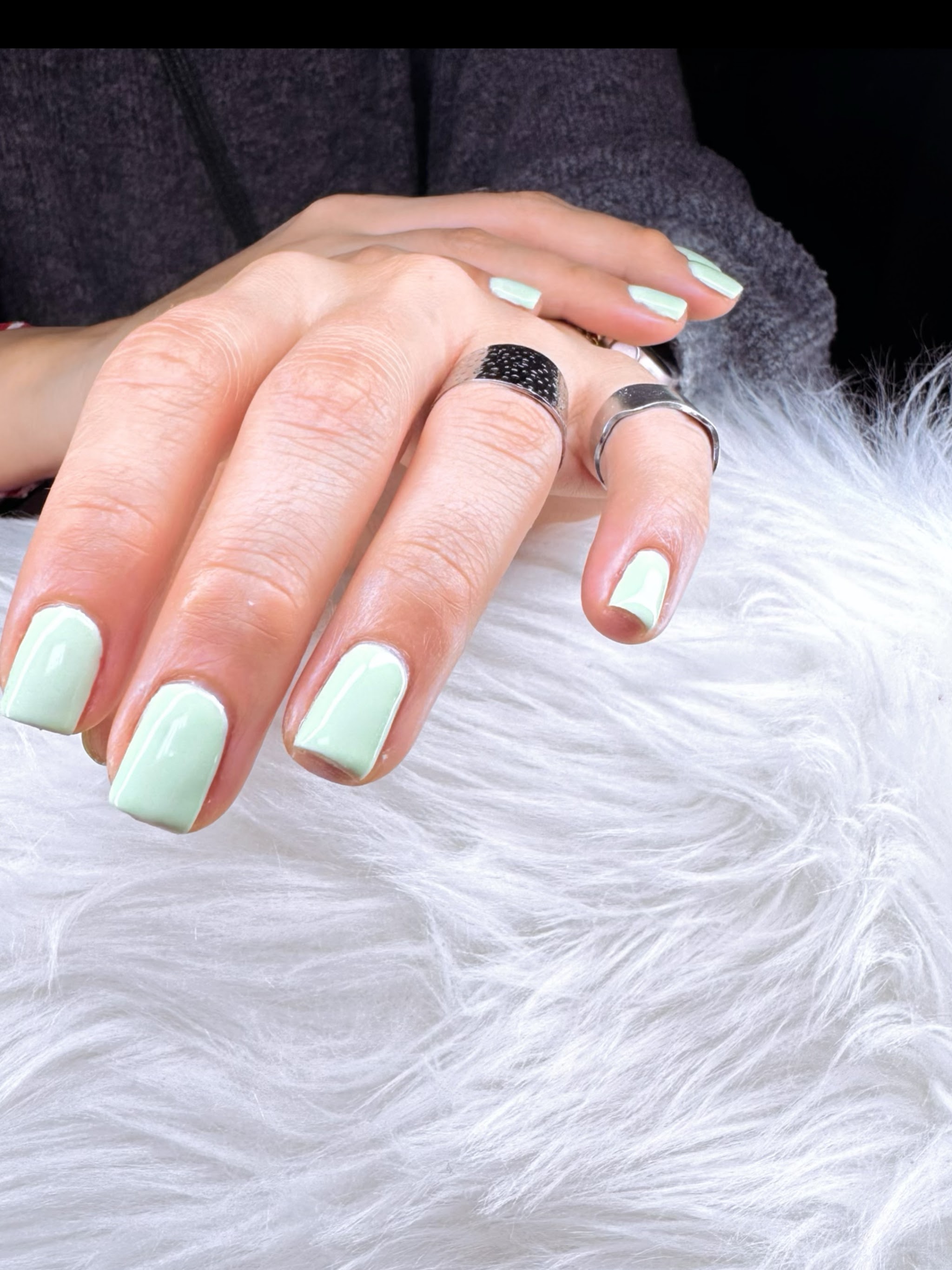 Mintgroene gelnagels op een witte vacht
