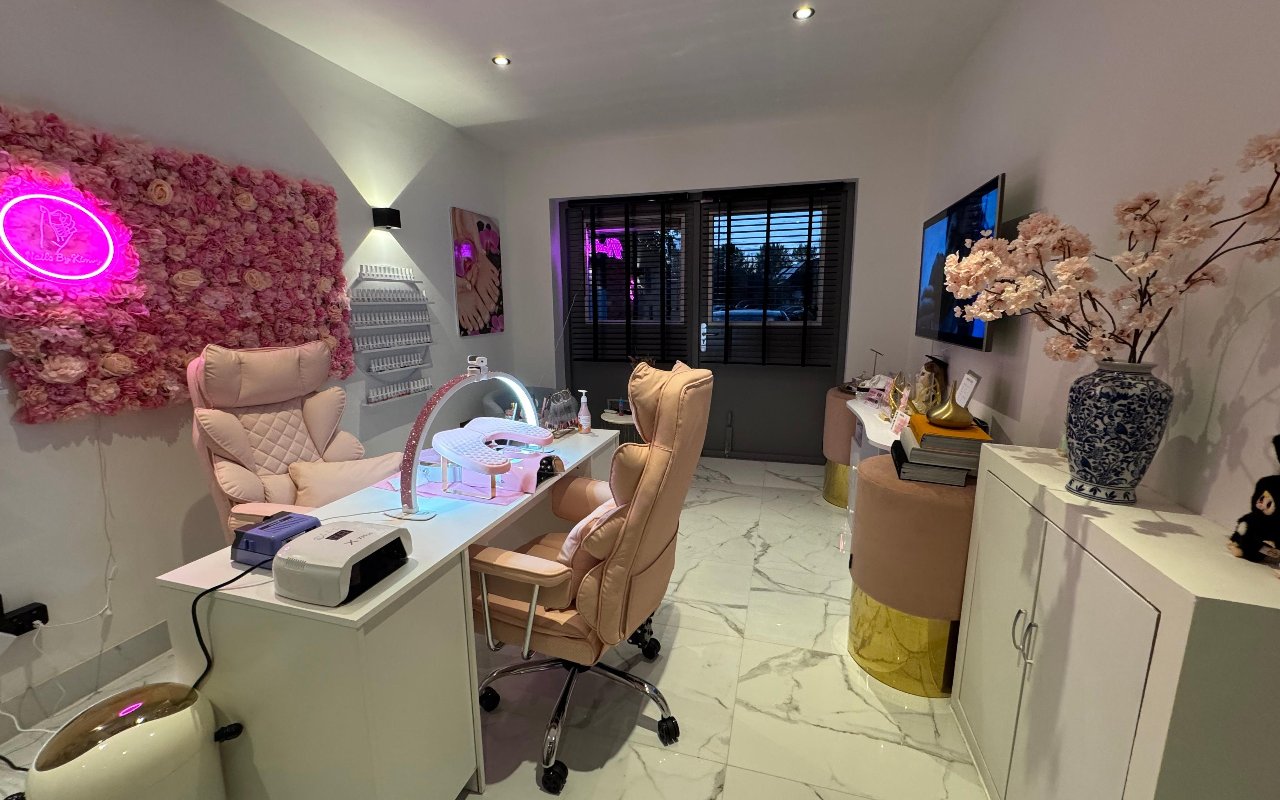 De nageltafel met roze stoelen op een marmeren vloer