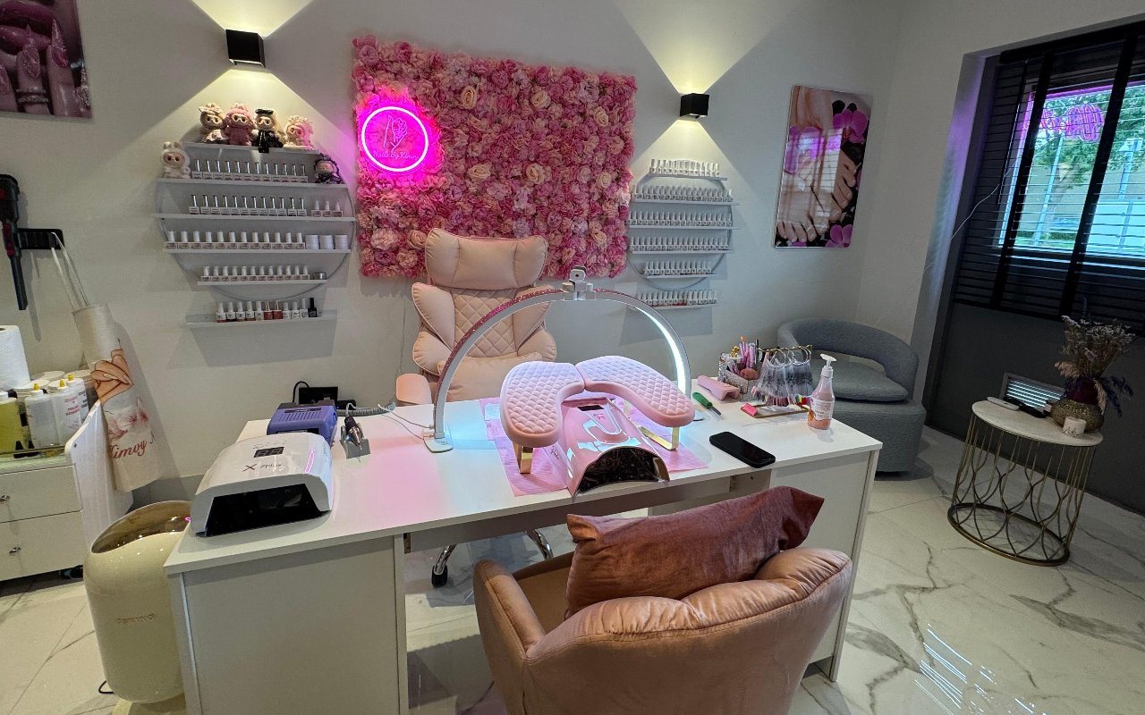 De salon met werktafel, roze stoelen en de bloemenwand