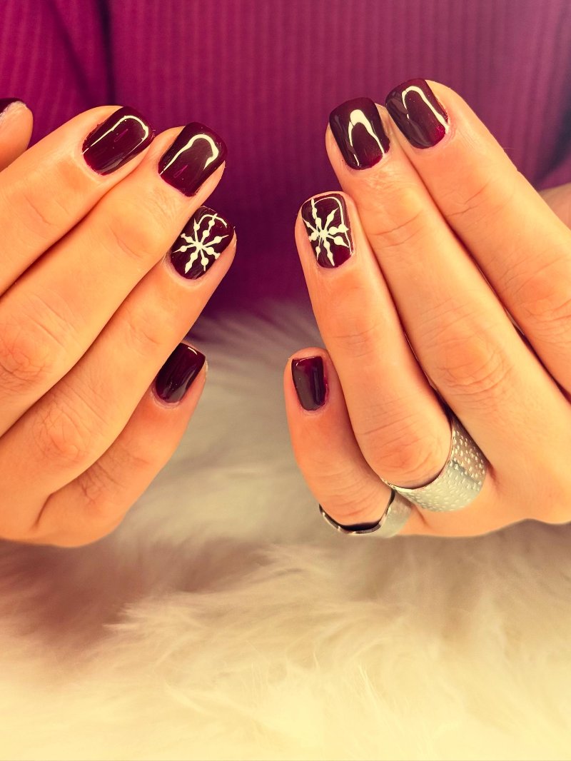 Bordeauxrode nagels met sneeuwvlok nail art